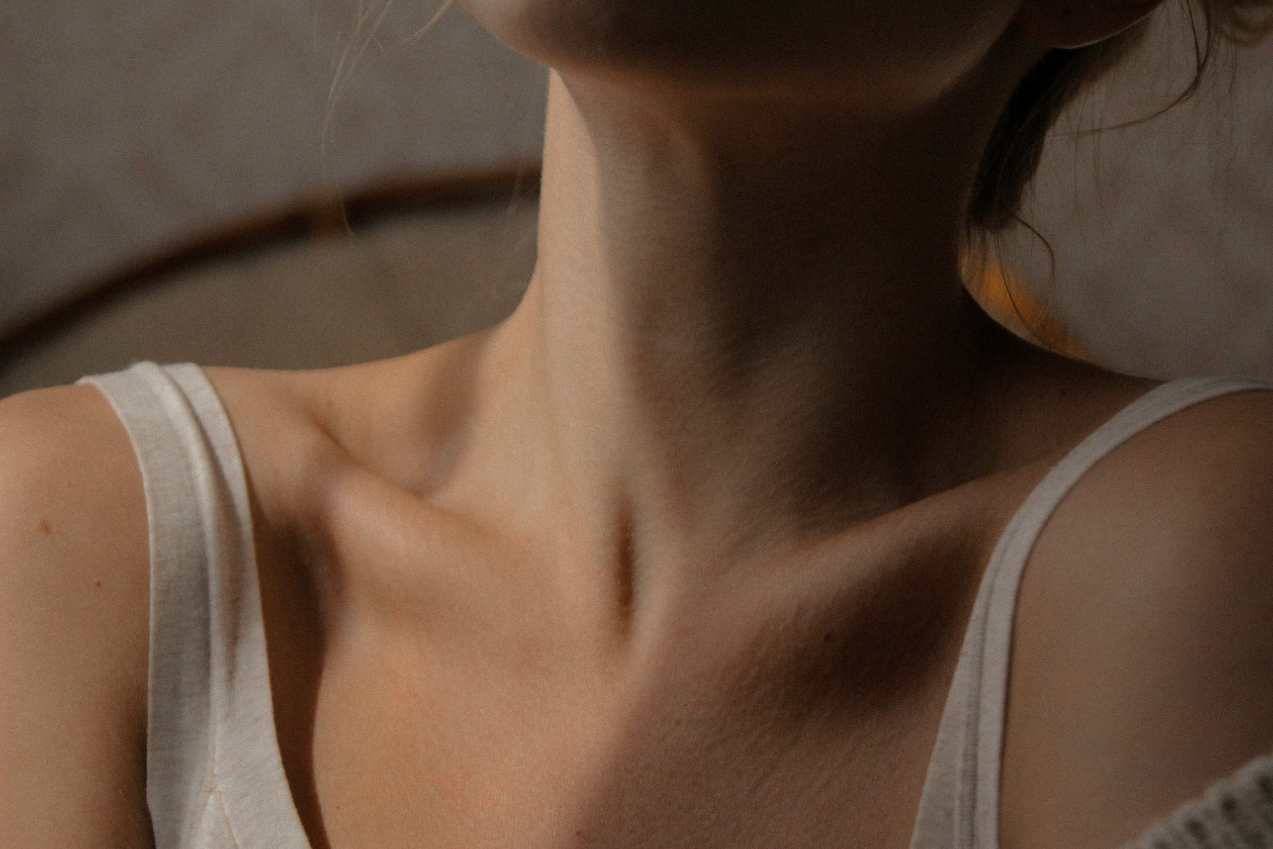 Close-up of woman's neck showing skin changes during menopause, highlighting dry, aging skin.