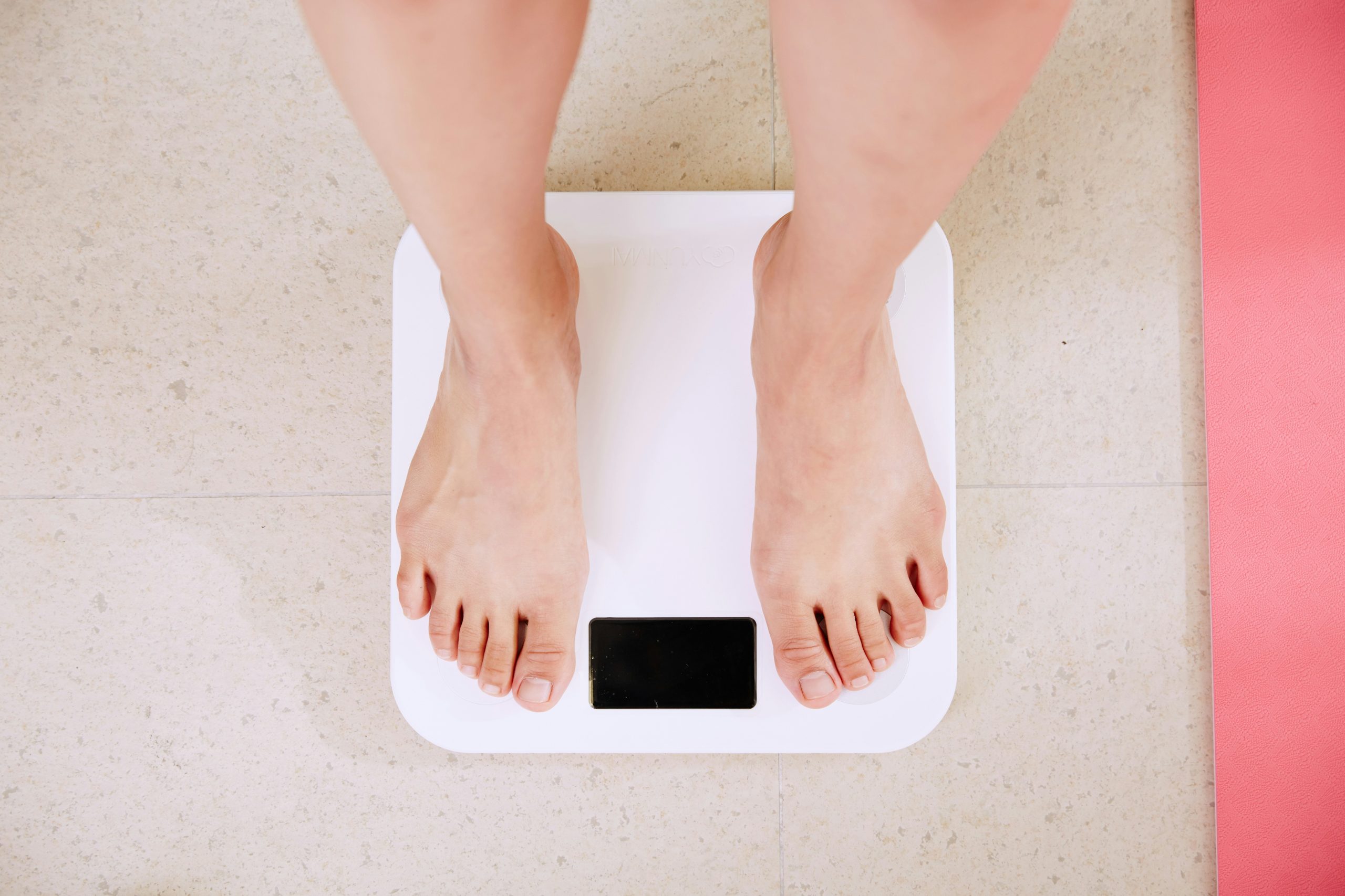 Menopause weight changes, woman standing on scales during menopause.