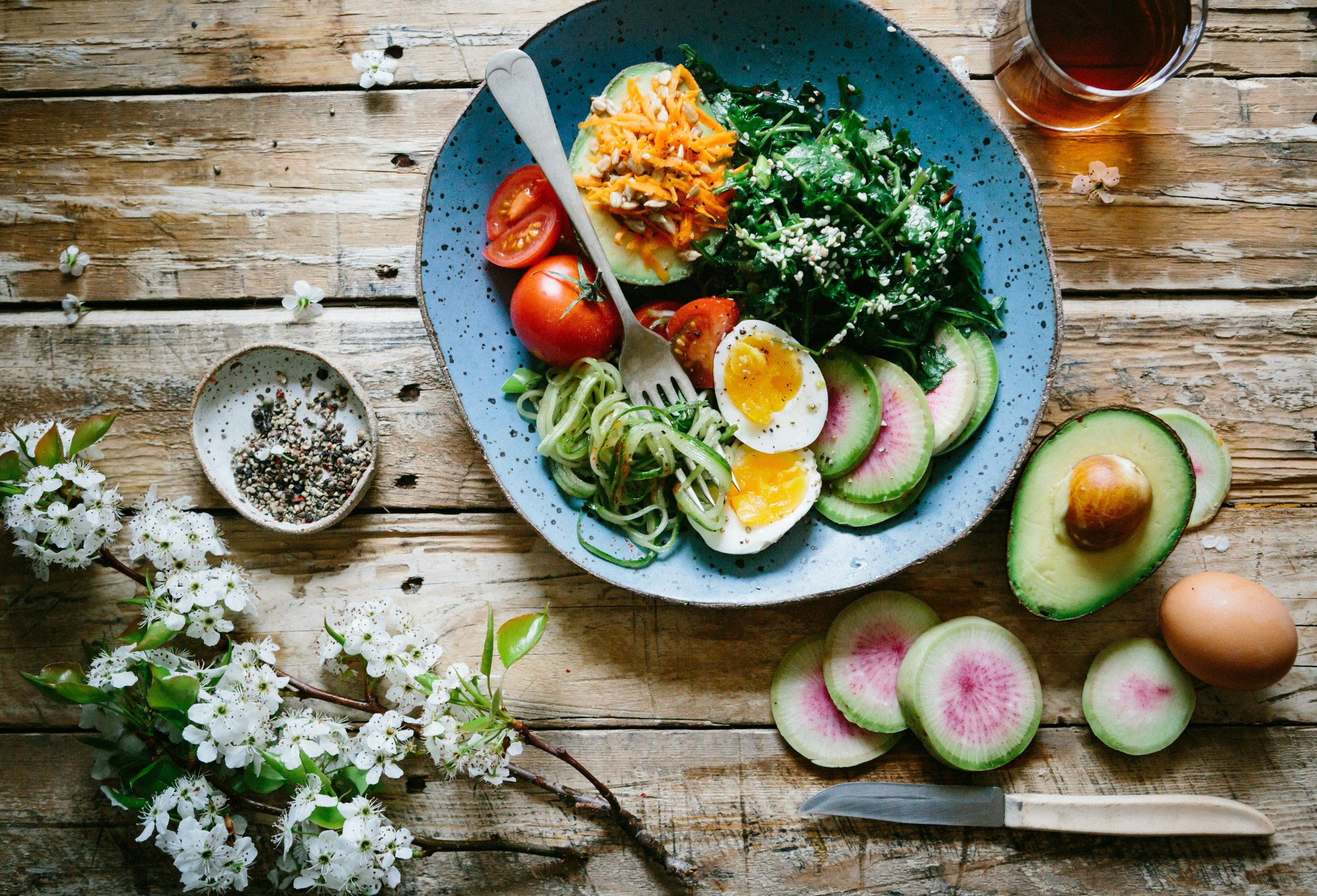 Healthy food bowl on wooden table with nutritious ingredients scattered, perfect for perimenopause nutrition.