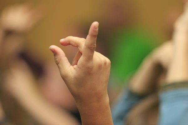 A woman's hand holding up one finger as to the number 1