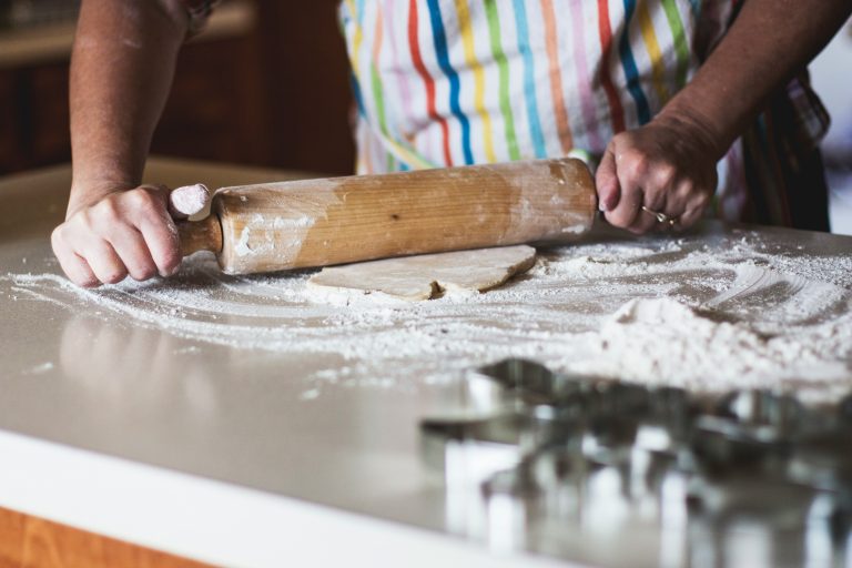 Woman baking at a kitchen table as a mindful wellbeing activity during perimenopause.