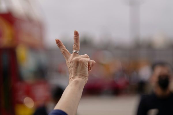 A woman's hand holding up two fingers as to the number 1