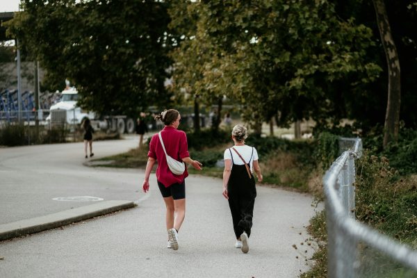 Two midlife women walking in a park during perimenopause, embracing movement and healthy lifestyle changes