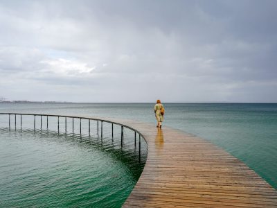 Perimenopause: A Journey of Change – A woman walks alone along a bridge, symbolizing the transition of perimenopause. This phase, leading up to menopause, brings hormonal shifts, irregular periods, mood changes, and symptoms like hot flashes and fatigue. Understanding perimenopause helps women navigate this natural stage with confidence and self-care. #Perimenopause #MenopauseJourney #HormonalHealth #WomensWellness