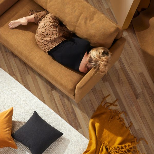 “Woman resting on couch, tired and fatigued, menopause symptom”