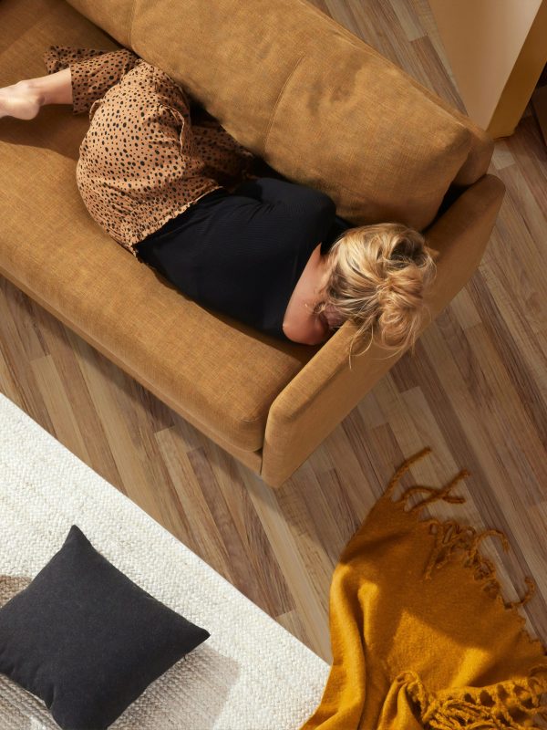 “Woman resting on couch, tired and fatigued, menopause symptom”