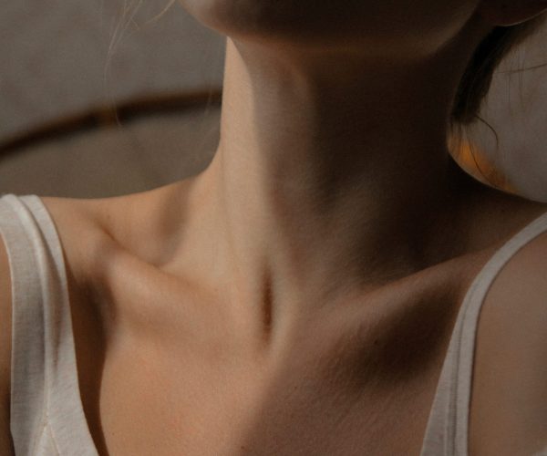 Close-up of woman's neck showing skin changes during menopause, highlighting dry, aging skin.